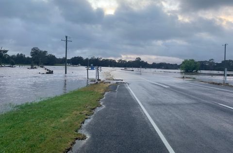 Flood waters across a rural road. 